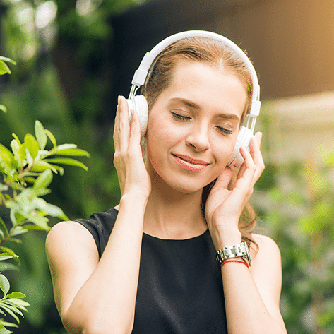 Meditation Frau hat Kopfhörer auf um binaurale Beats zu hören und um keine Probleme mehr zu haben