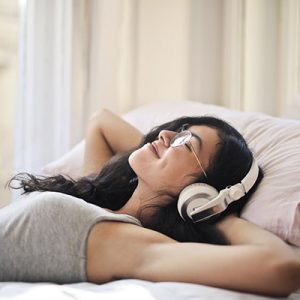 Dm-Harmonics-folgen von zu wenig schlaf-Frau liegt im Bett Dm-Harmonics-folgen von zu wenig schlaf-Frau liegt mit Kopfhörern im Bett