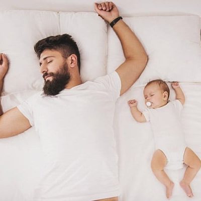DM-Harmonics-schlafen wie ein Murmeltier-Mann und Baby liegen nebeneinander im Bett