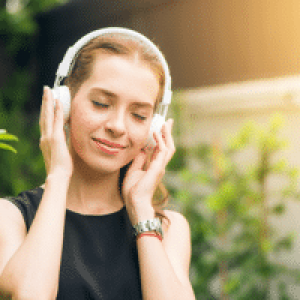 Frau hat Kopfhörer auf um binaurale Beats zu hören und um keine Probleme mehr zu haben
